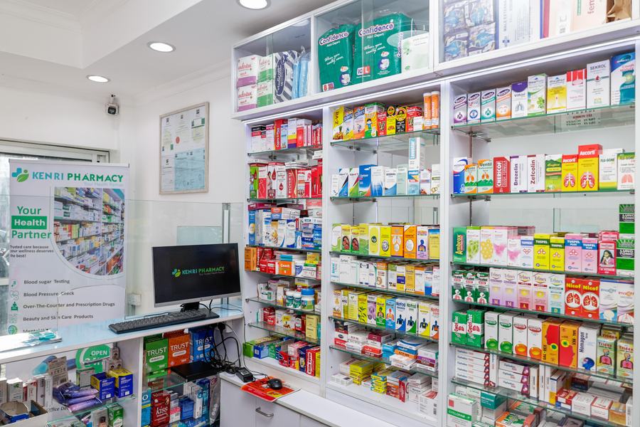 Pharmacy dispensing counter with glass display cabinets and wall shelving, Kenri Pharmacy Ngong